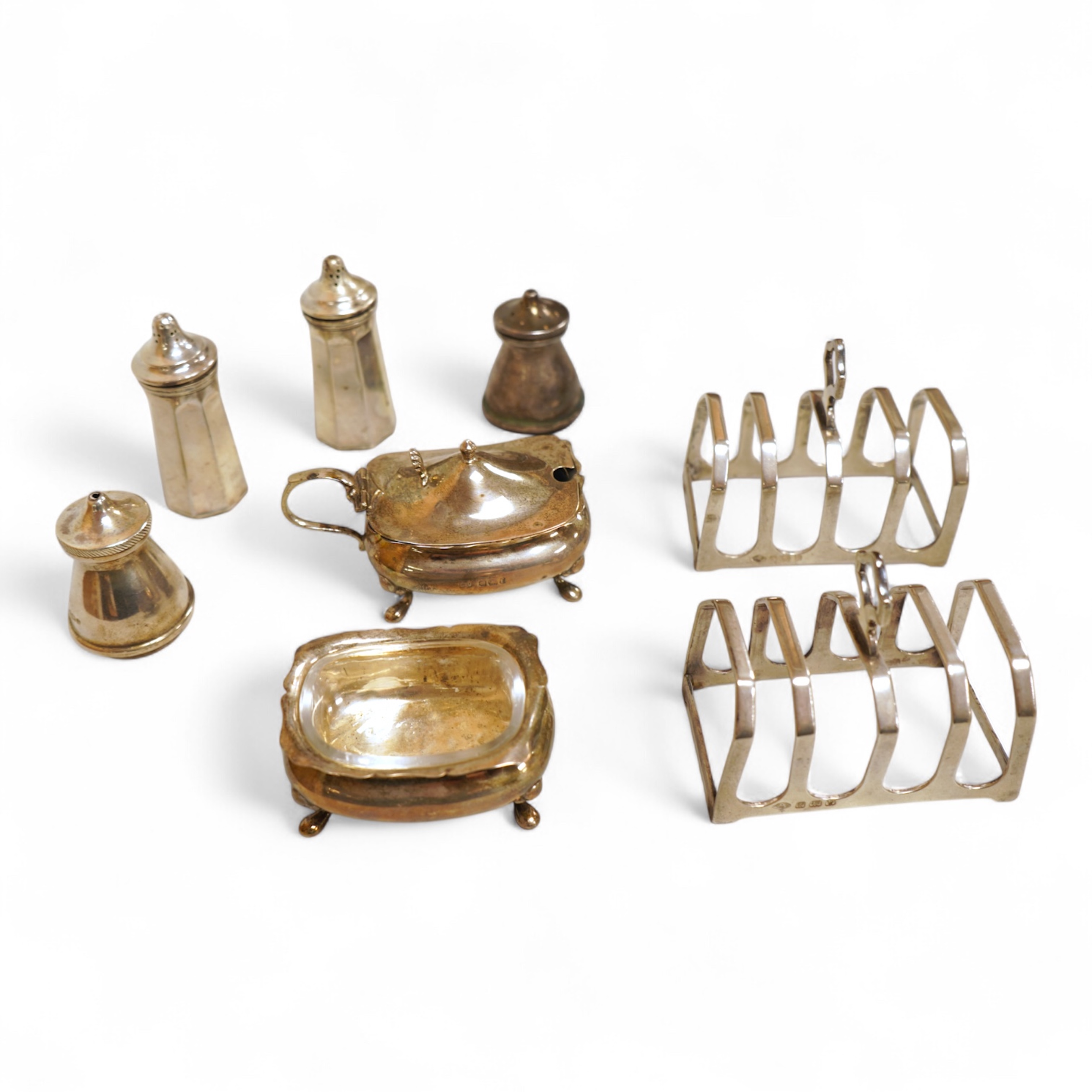 A pair of small George V silver five bar toast racks, Adie Brothers, Birmingham, 1930, length 76mm, together with six assorted silver condiments.